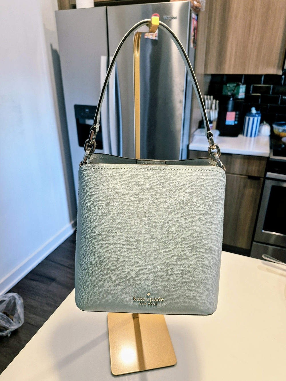 light green or pastel blue leather bucket bag that resembles the Kate Spade Darc